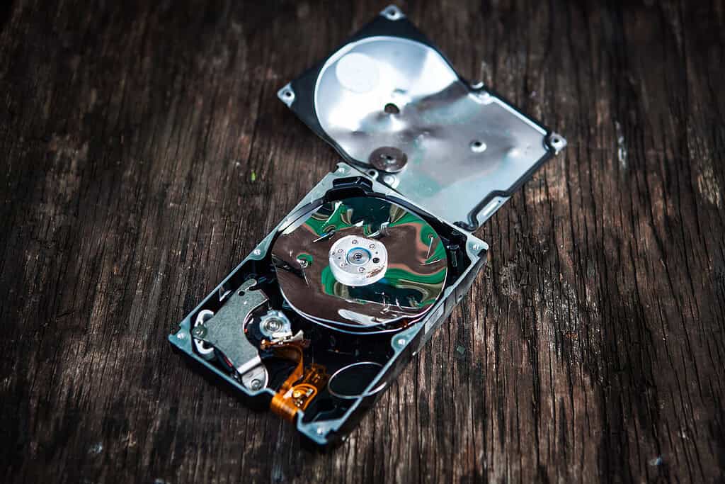Crushed Hard Disk Drive on the Old Wooden Table